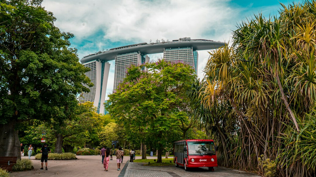 Colleagues having a walking meeting in a park near Singapore office buildings