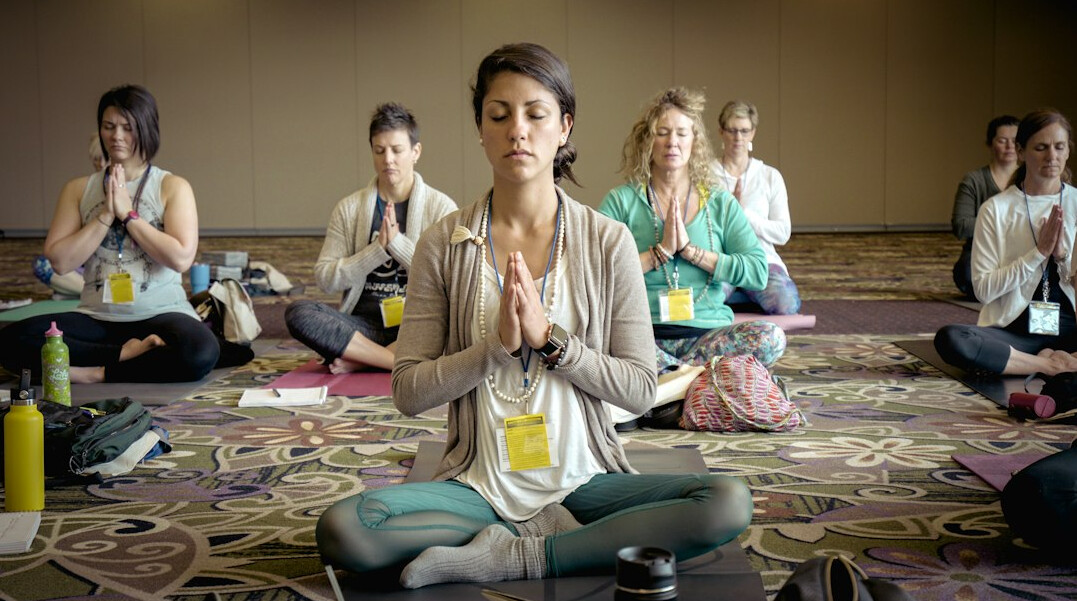 Employees practising yoga together in an office wellness studio